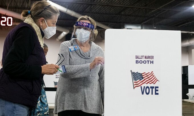 Tình nguyện viên hướng dẫn cử tri tại điểm bỏ phiếu sớm tại Ohio ngày 6/10. Ảnh: AFP.
