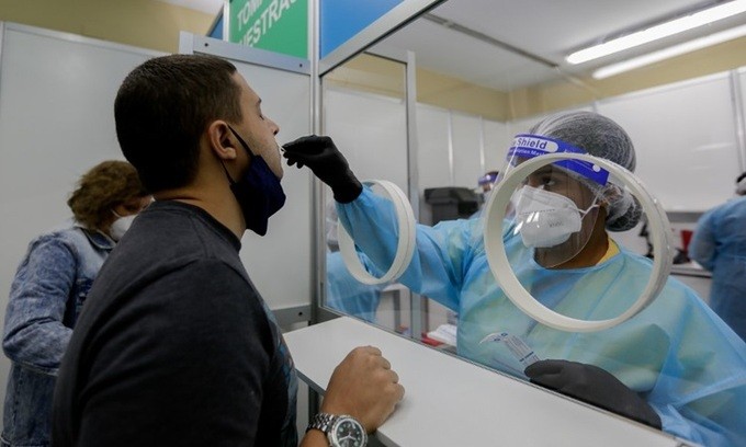 Nhân viên y tế lấy mẫu xét nghiệm Covid-19 cho một người đàn ông ở Sân bay Quốc tế Tocumen, Panama City, thủ đô của Panama hôm 12/10. Ảnh: AFP.