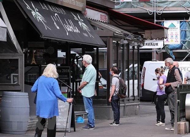 Người dân xếp hàng bên ngoài một hiệu bánh ở Paris, Pháp. (Ảnh: THX/TTXVN).