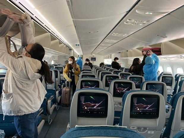 Hành khách trên một chuyến bay thực hiện nghiêm việc đeo khẩu trang theo đúng quy định. (Ảnh: CTV/Vietnam+).