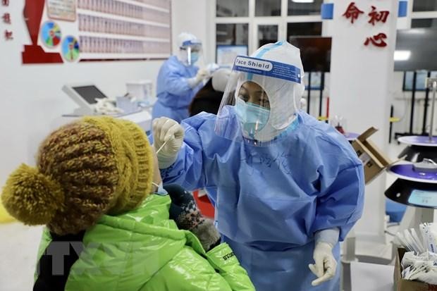 Nhân viên y tế lấy mẫu dịch xét nghiệm COVID-19 cho người dân tại thành phố Tuy Phân Hà, tỉnh Hắc Long Giang, Trung Quốc. (Ảnh: THX/TTXVN)