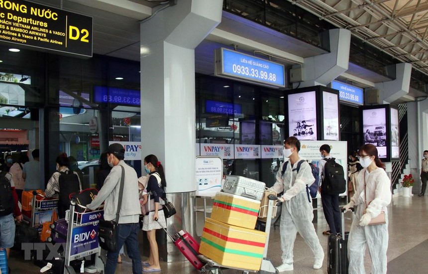 Để phòng chống dịch, nhiều hành khách đã chủ động trang bị các bộ đồ bảo hộ khi đến sân bay Tân Sơn Nhất. (Ảnh: Tiến Lực/TTXVN).