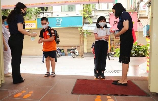 Học sinh được hướng dẫn các biện pháp phòng, chống dịch bệnh khi đến lớp. (Ảnh: TTXVN).
