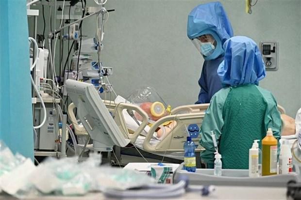 Nhân viên y tế điều trị cho bệnh nhân COVID-19 tại bệnh viện. (Ảnh: AFP/TTXVN).