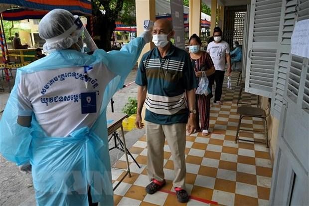 Kiểm tra thân nhiệt phòng lây nhiễm COVID-19 tại Phnom Penh, Campuchia. (Ảnh: AFP/TTXVN).