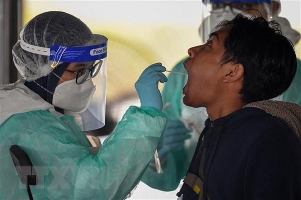 Nhân viên y tế lấy mẫu xét nghiệm COVID-19 cho người dân tại Kuala Lumpur, Malaysia. (Nguồn: AFP/TTXVN).