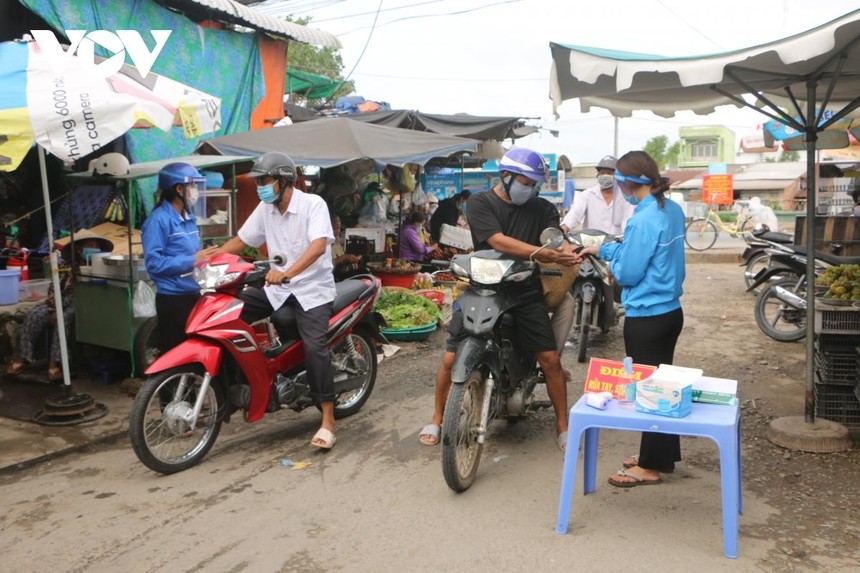 Do thân nhiệt và rửa tay sát khuẩn ở một khu vực chợ tại tỉnh Sóc Trăng.