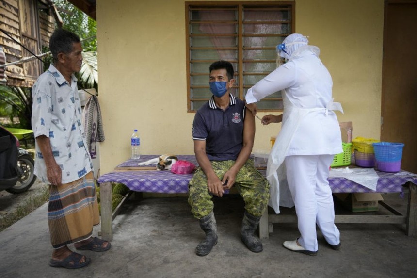 Một nhân viên y tế đang chuẩn bị tiêm vaccine Pfizer cho một nông dân ở bang Selangor. Ảnh: AP.