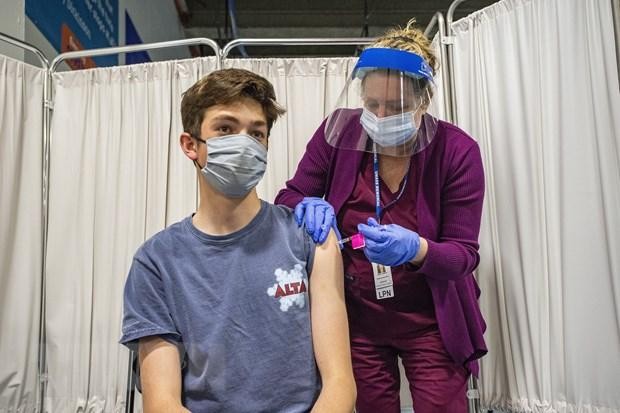 Một thiếu niên 16 tuổi được tiêm vaccine ngừa COVID-19 của Pfizer/BioNTech. (Ảnh: AFP/TTXVN).