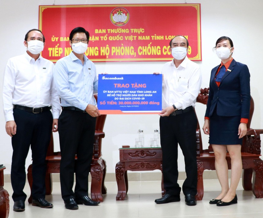 Đại diện Sacombank - ông Trần Minh Tâm, Giám đốc Chi nhánh Long An (bên trái), trao tặng 30 tỷ đồng cho Ủy ban Mặt trận Tổ quốc VN tại Long An để hỗ trợ người dân khó khăn do Covid-19.