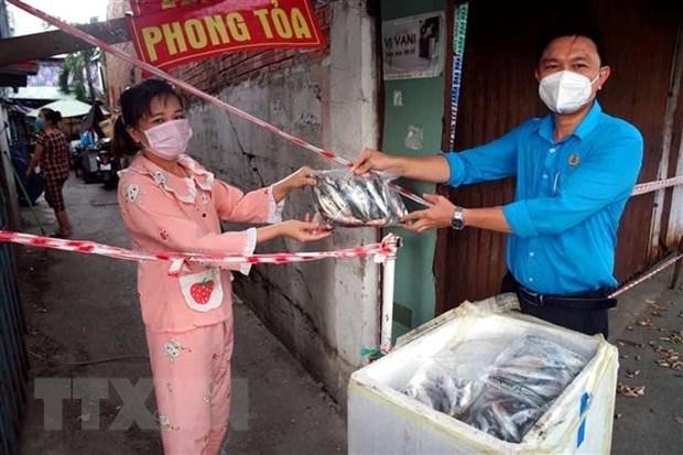 Liên đoàn Lao động quận 8 trao tặng cá của ngư dân tỉnh Quảng Bình cho người lao động khu vực phong tỏa. (Ảnh: Thanh Vũ/TTXVN).