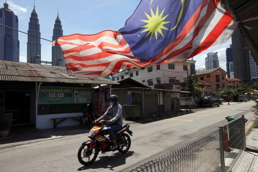 Một người đàn ông đeo khẩu trang lái xe máy trên đường phố Kuala Lumpur, Malaysia ngày 2/2/2021. Ảnh: Reuters.