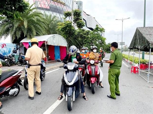 Lực lượng Công an tại chốt kiểm trên đường Phạm Văn Đồng (phường Hiệp Bình Chánh, Thủ Đức) kiểm tra giấy tờ của người lưu thông. (Ảnh: Thành Chung/TTXVN).
