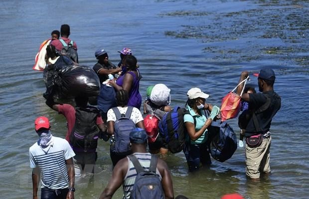 Người di cư băng qua sông ở bang Coahuila, Mexico. (Ảnh: AFP/TTXVN).