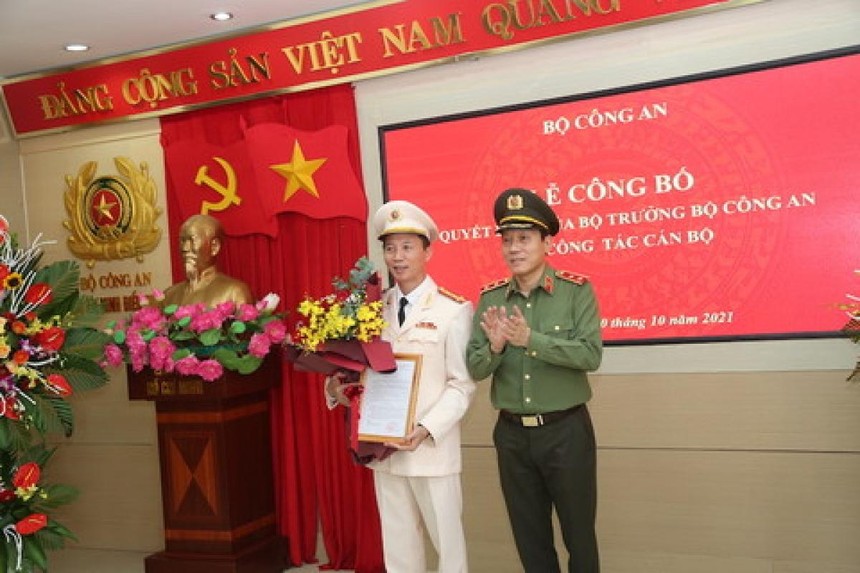 Thứ trưởng Lương Tam Quang trao quyết định và tặng hoa chúc mừng Đại tá Vũ Hoài Bắc.