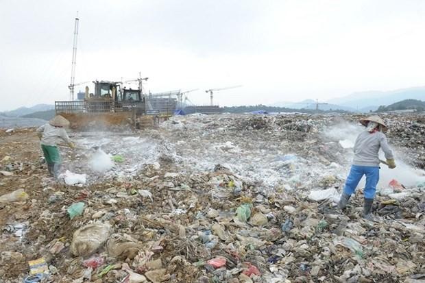 Công ty TNHH MTV Môi trường Đô thị Hà Nội rắc chế phẩm khử mùi tại bãi rác Nam Sơn. (Ảnh: Mạnh Khánh/TTXVN).