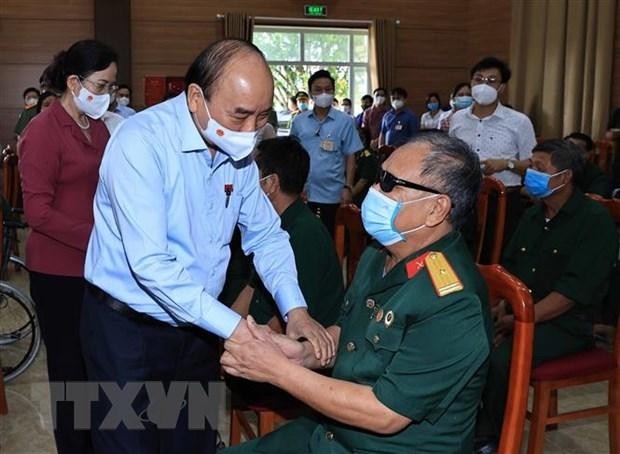 Chủ tịch nước Nguyễn Xuân Phúc đến thăm, tặng quà cho thương binh, bệnh binh tại Trung tâm nuôi dưỡng thương bệnh binh nặng và điều dưỡng người có công tỉnh Hà Nam. (Ảnh: Thống Nhất/TTXVN).