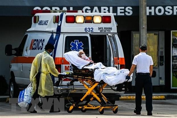 Nhân viên y tế chuyển bệnh nhân COVID-19 tới bệnh viện ở Coral Gables, gần Miami, Mỹ. (Ảnh: AFP/TTXVN).