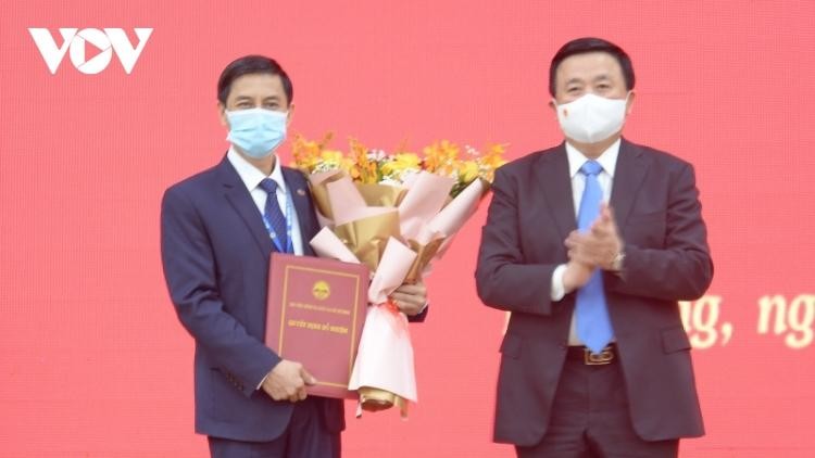 Ông Nguyễn Xuân Thắng, Ủy viên Bộ Chính trị trao Quyết định, tặng hoa chúc mừng ông Đoàn Triệu Long.