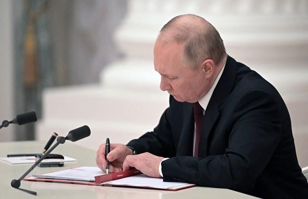 Tổng thống Nga Vladimir Putin ký sắc lệnh công nhận nền độc lập của hai nước Cộng hòa tự xưng Donetsk và Luhansk ở miền Đông Ukraine, tại cuộc họp khẩn với Hội đồng An ninh ở Moskva, ngày 21/2/2022. (Ảnh: AFP/TTXVN).
