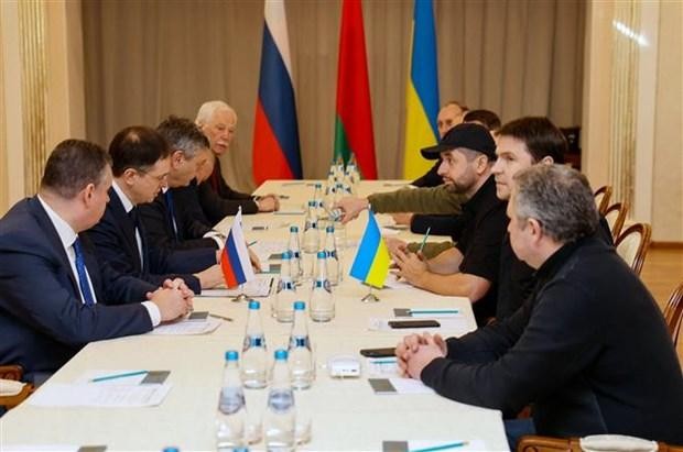 Các thành viên phái đoàn Nga (trái) và Ukraine tại vòng đàm phán ở vùng Gomel, Belarus, ngày 28/2/2022. (Ảnh: AFP/TTXVN).