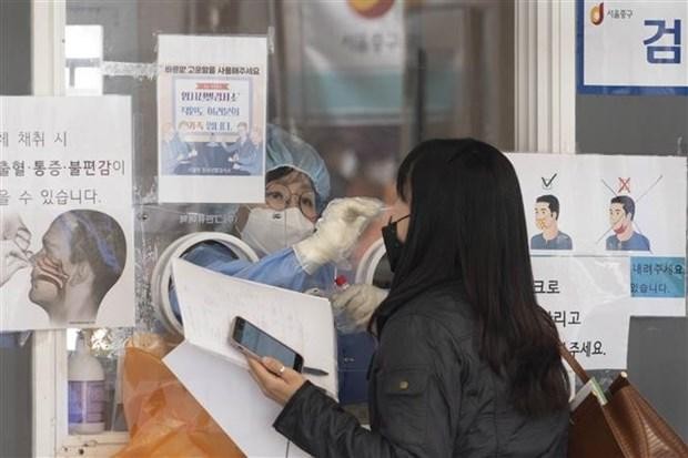 Nhân viên y tế lấy mẫu xét nghiệm COVID-19 cho người dân tại Seoul, Hàn Quốc. (Ảnh: THX/ TTXVN)