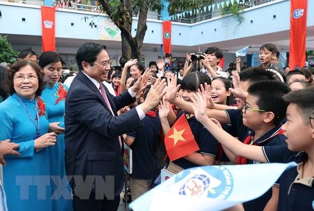 Thủ tướng Phạm Minh Chính với học sinh Trường Tiểu học Đoàn Thị Điểm. (Ảnh: Dương Giang/TTXVN).