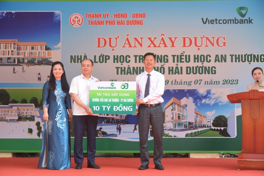 Đại diện Vietcombank, ông Nguyễn Xuân Cao Cường - Giám đốc Vietcombank Hải Dương trao biển tượng trưng tài trợ kinh phí xây dựng trường cho đại diện lãnh đạo UBND thành phố và hiệu trưởng trường tiểu học An Thượng.