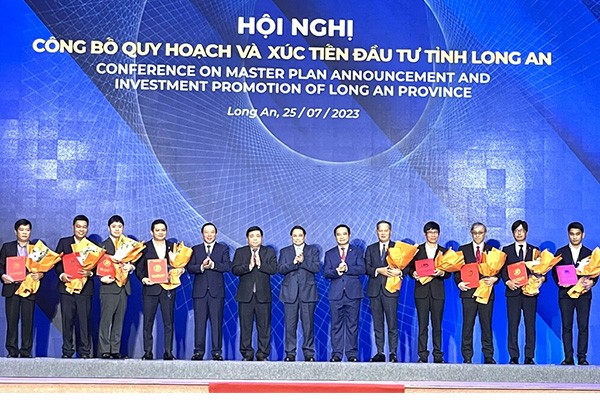 Thủ tướng Phạm Minh Chính trao giấy chứng nhận đầu tư và chụp ảnh lưu niệm cùng các doanh nghiệp.