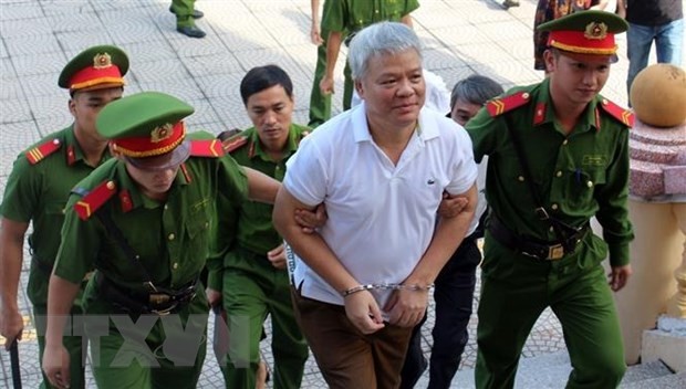 Lực lượng chức năng dẫn giải bị cáo Nguyễn Văn Khuê vào phòng xét xử. (Ảnh: Vũ Hà/TTXVN)
