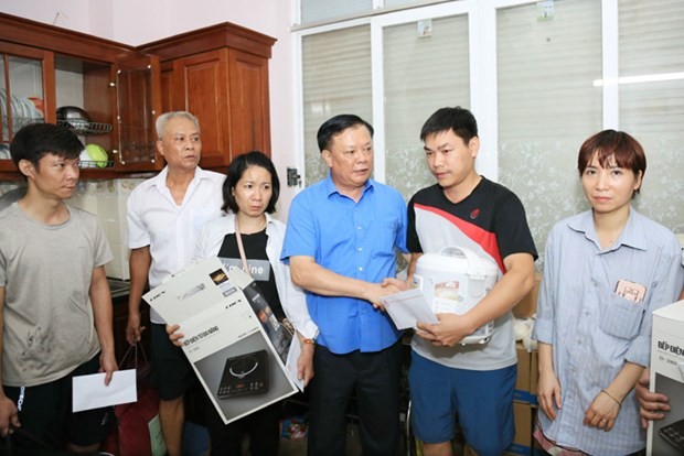 Bí thư Thành ủy Đinh Tiến Dũng động viên, trao hỗ trợ cho các gia đình trong vụ cháy chung cư mini tại quận Thanh Xuân. (Ảnh: Xuân Quảng/Vietnam+).