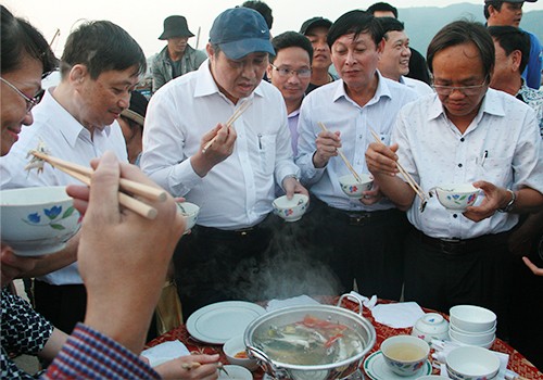 Ông Huỳnh Đức Thơ (người đội mũ) đã trực tiếp chế biến và thưởng thức hải sản của ngư dân ngay tại cảng cá. Ảnh: Đ.X.