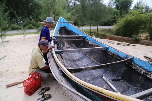Ông Sơn (huyện Gio Linh, Quảng Trị) cùng con trai đưa chiếc thuyền nan 90CV lên bờ để tu sửa, chờ mùa biển mới.