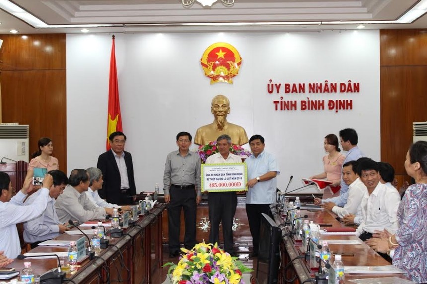 Bộ trưởng Nguyễn Chí Dũng trao số tiền ủng hộ nhân dân bị thiệt hại do lũ lụt cho lãnh đạo tỉnh Bình Định
