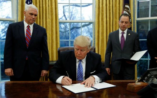  Ông Trump ký sắc lệnhhành pháp (executive order)dưới sự chứng kiến của Phó tổng thống - Mike Pence (trái) và Chánh Văn phòng Nhà Trắng -Reince Priebustại Phòng Bầu dụcngày 23/1 (theo giờ Washington). Ảnh:Reuters
