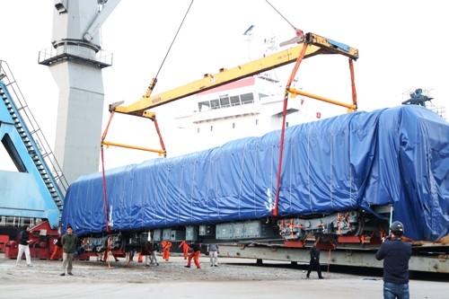 Đầu máy tàu nặng 35 tấn, dài 19 m, cao 3,8 m, rộng ngang 2,8 m được cẩu từ trên tàu xuống sân bãi. Ảnh: Giang Chinh