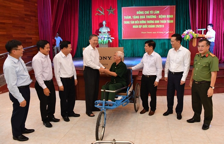 Đại tướng Tô Lâm (thứ 4 từ trái sang) cùng Tổng Giám đốc Vietcombank Phạm Quang Dũng (thứ 2 từ phải sang) thăm hỏi và tặng quà đại diện các đ/c thương binh tại Trung tâm.