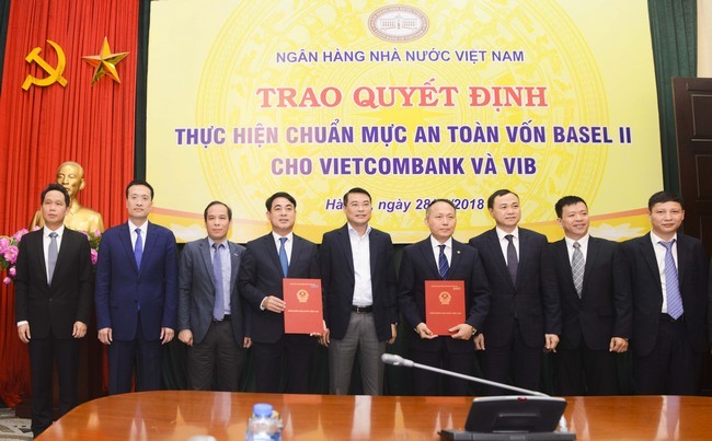 Thống đốc NHNN Việt Nam Lê Minh Hưng (đứng giữa) cùng Phó thống đốc NHNN Đoàn Thái Sơn (thứ 3 từ trái sang) trao quyết định cho Vietcombank và VIB