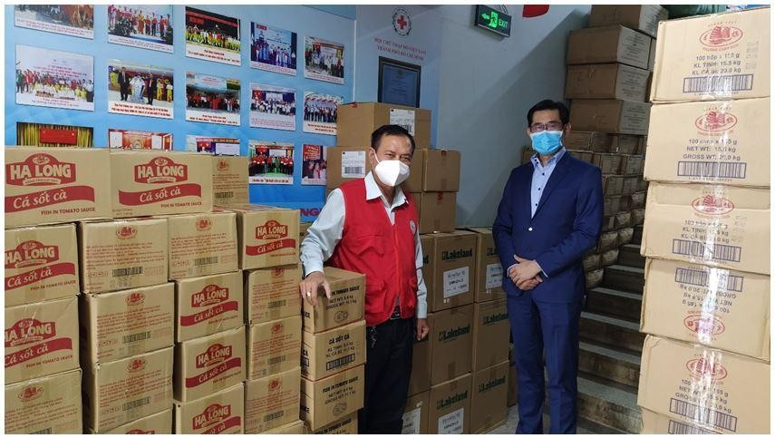 Ông Harry Loh, Tổng giám đốc Ngân hàng UOB Việt Nam (phải) và ông Trần Trường Sơn, Chủ tịch Hội Chữ thập đỏ TP.HCM (trái) cùng với số lượng đồ hộp và vật tư y tế sẵn sàng để phân phối