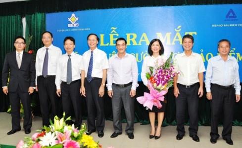 Thứ trưởng Bộ Tài chính Trần Xuân Hà tặng hoa và chụp ảnh lưu niệm cùng các thành viên Hội đồng quản lý Quỹ Bảo vệ người được bảo hiểm 