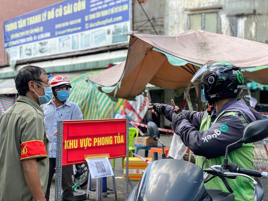 Tài xế giao hàng của GoJek Việt Nam giao hàng đến khu vực phong toả (Ảnh: Q.T).
