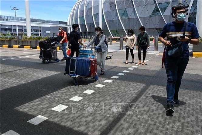 Hành khách đeo khẩu trang phòng dịch COVID-19 tại sân bay quốc tế Changi, Singapore. Ảnh: AFP/TTXVN