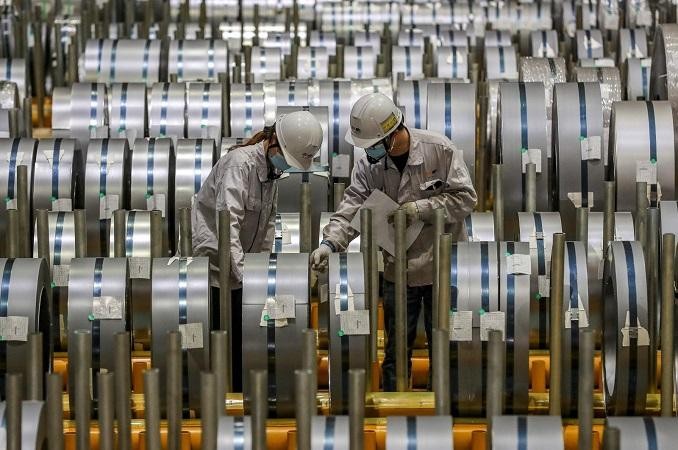 Công nhân kiểm tra sản phẩm nhôm cuộn bên trong một nhà máy ở thành phố Vũ Hán, tỉnh Hồ Bắc, Trung Quốc. Ảnh: AFP