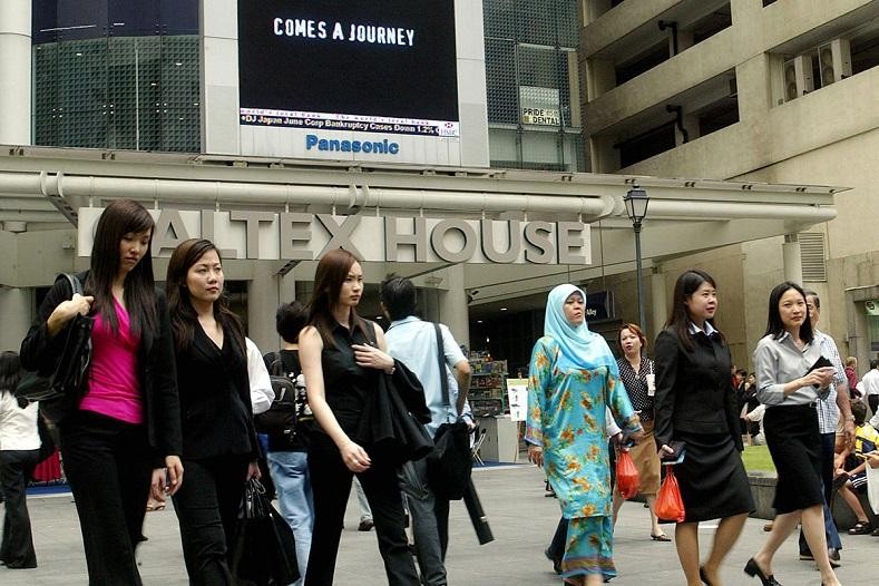 Các nhân viên văn phòng đi bộ tại trung tâm tài chính Raffles Place ở Singapore. Ảnh: AFP