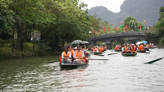 Các đại biểu tham quan quần thể danh thắng Tràng An bằng thuyền.