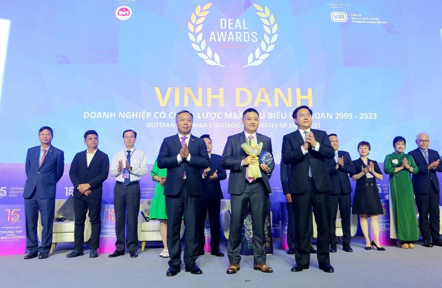 Ông Trần Duy Đông, Thứ trưởng Bộ Kế hoạch và Đầu tư (phải) và ông Lê Trọng Minh, Tổng Biên tập Báo Đầu tư, Trưởng Ban tổ chức Diễn đàn M&A Việt Nam 2023 trao Cup Vinh danh và tặng hoa chúc mừng cho đại diện Tập đoàn Masan (giữa)