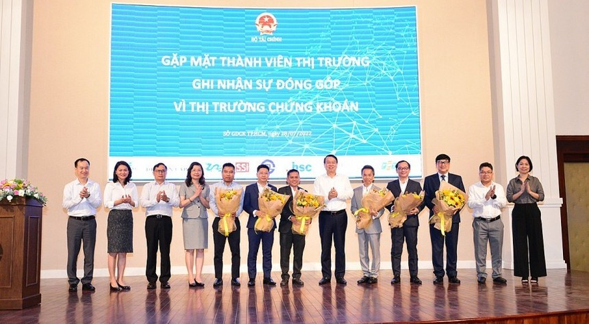 Thứ trưởng Bộ Tài chính Nguyễn Đức Chi (thứ 6 từ trái sang) tặng hoa cảm ơn các thành viên thị trường ngày 28/7/2022 