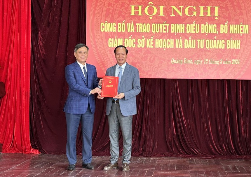 Chủ tịch UBND tỉnh Quảng Bình Trần Thắng (bên trái) trao quyết định và tặng hoa chúc mừng Giám đốc Sở Kế hoạch và Đầu tư Quảng Bình Nguyễn Xuân Đạt.