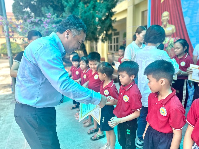 Tổng Biên tập Báo Đầu tư Lê Trọng Minh trao học bổng cho các em học sinh trường Tiểu học Khả Phong.