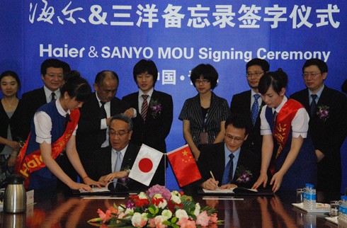 Ông LIANG Haishan, Phó Chủ tịch cấp cao của Tập đoàn Haier (ngồi, bên phải), và ông Mitsuru HOMMA, Phó Chủ tịch của SANYO Electric Co. Ltd (ngồi bên trái), ký MOU tại Thanh Đảo, Sơn Đông, Trung Quốc n